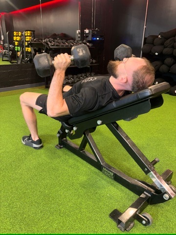 Lee Culbert demonstrating a dumbbell press during a coaching session